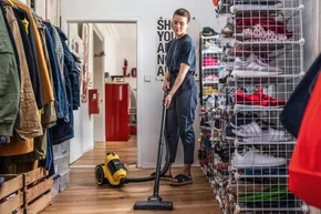 Person saugt in einem Raum mit einem Staubsauger